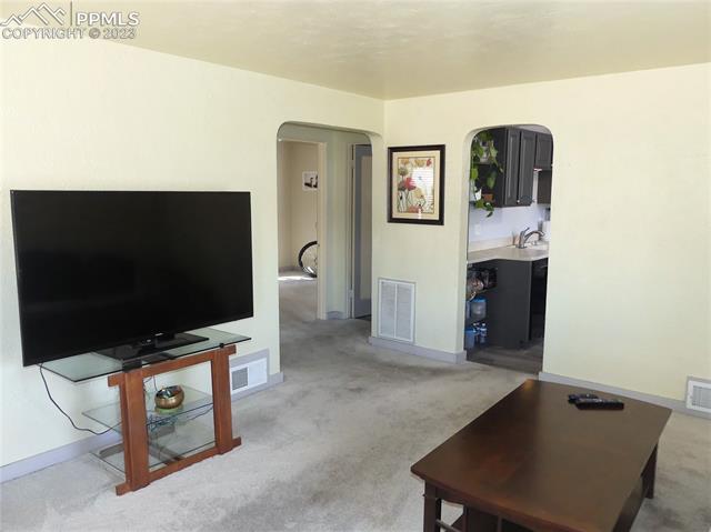 811 Prairie Road Colorado Springs, CO 80909 - Photo 6 of 28 Arched walkways between living room, kitchen and hallway
