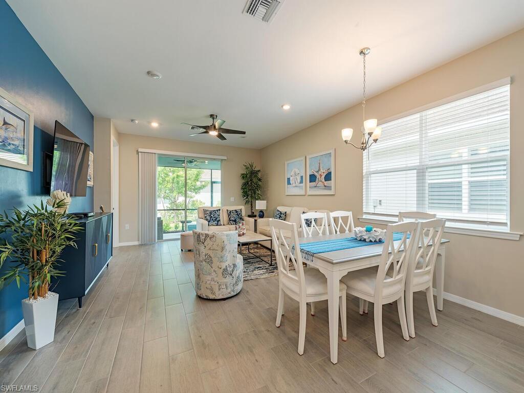 1209 Enbrook Loop Naples, FL 34114 - Photo 4 of 15 Dining room featuring light hardwood / wood-style floors and ceiling fan with notable chandelier
