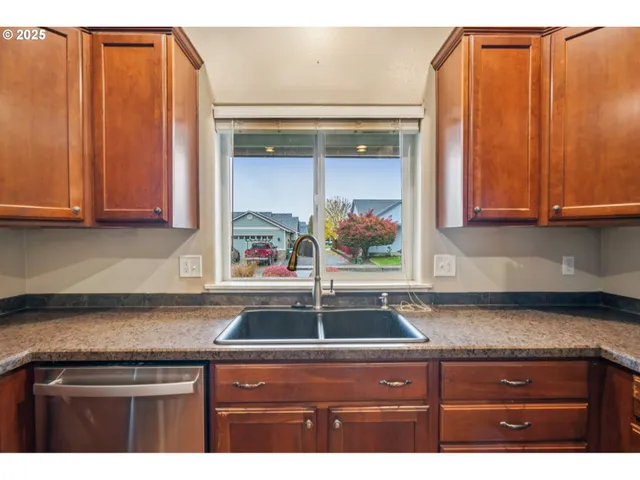 a kitchen with stainless steel appliances granite countertop a refrigerator and a sink
