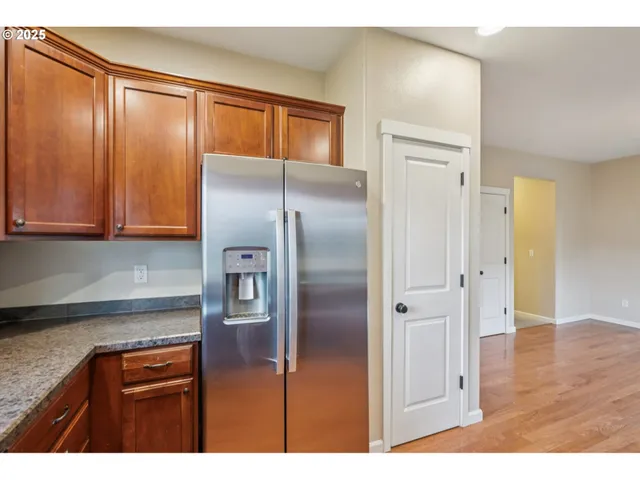 a view of a kitchen with granite countertop a sink dishwasher a stove and a wooden cabinets