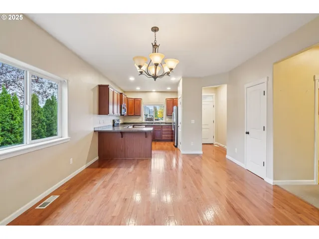 a kitchen with stainless steel appliances granite countertop wooden cabinets a stove a sink and a microwave