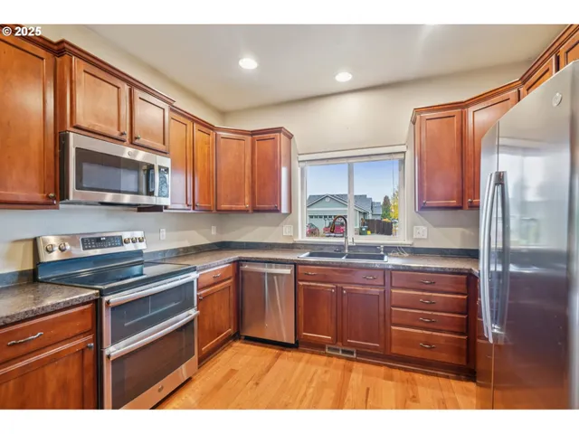 a kitchen with stainless steel appliances granite countertop a refrigerator and cabinets