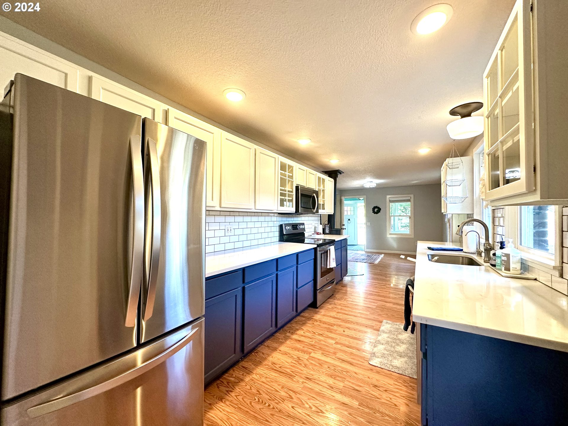 3010 R Street Vancouver, WA 98663 - Photo 15 of 43 a large kitchen with kitchen island a large window a sink and stainless steel appliances