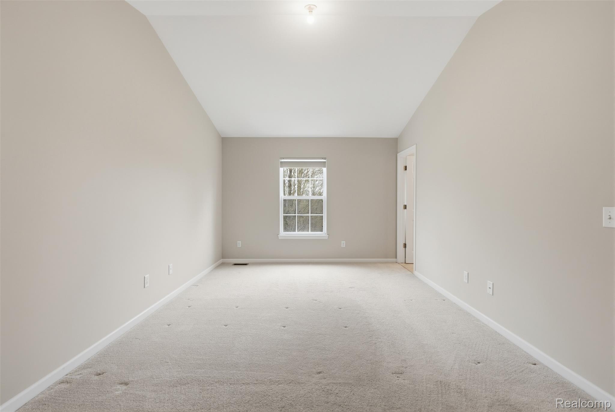 41594 Mitchell Road Novi, MI 48377 - Photo 18 of 35 Spare room with light colored carpet and vaulted ceiling