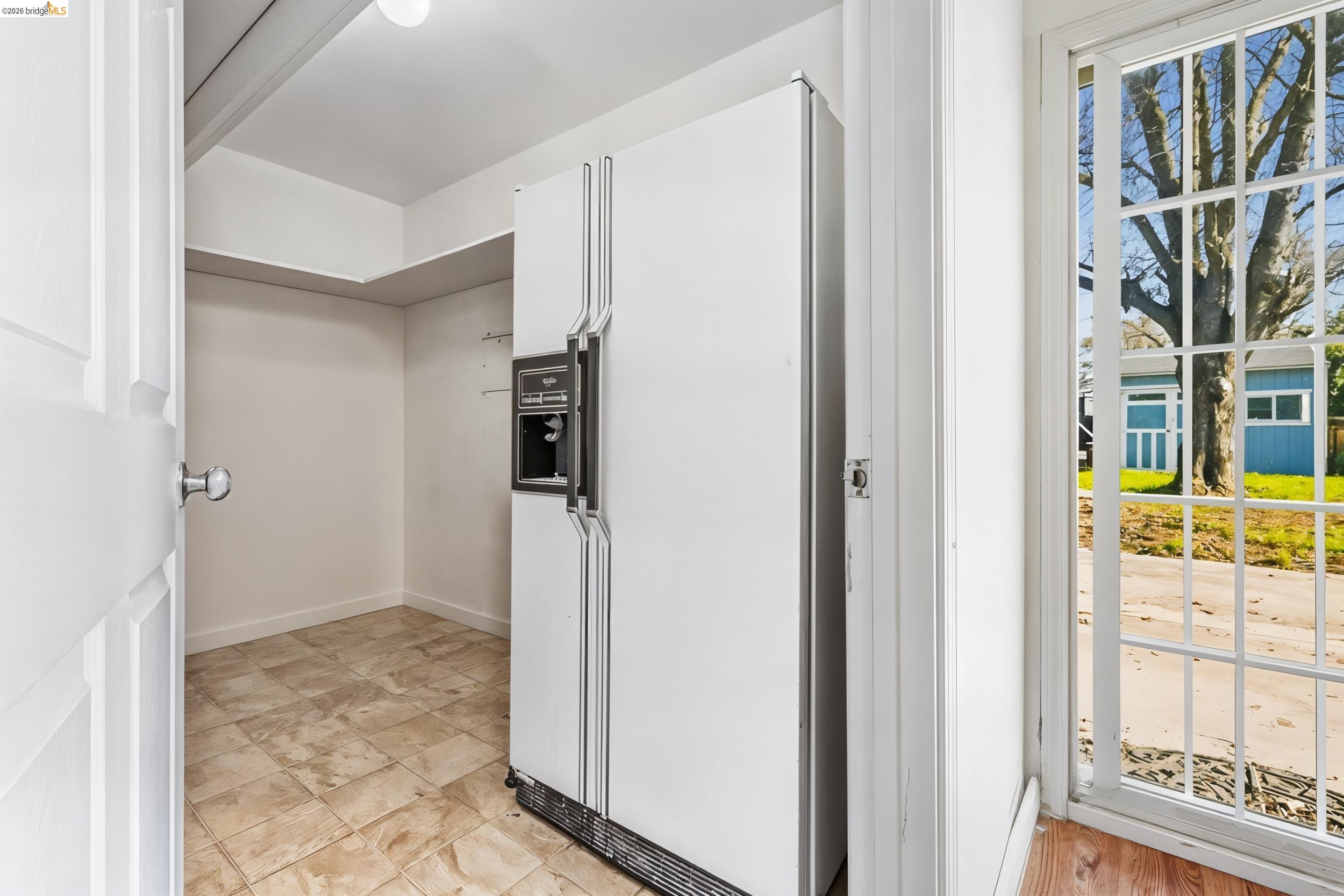 1704 East Street Tracy, CA 95376 - Photo 11 of 29 Kitchen featuring white fridge with ice dispenser and baseboards