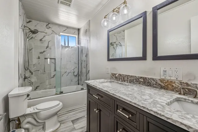a bathroom with a granite countertop sink toilet and shower