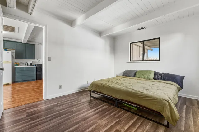 a bedroom with a bed and wooden floor