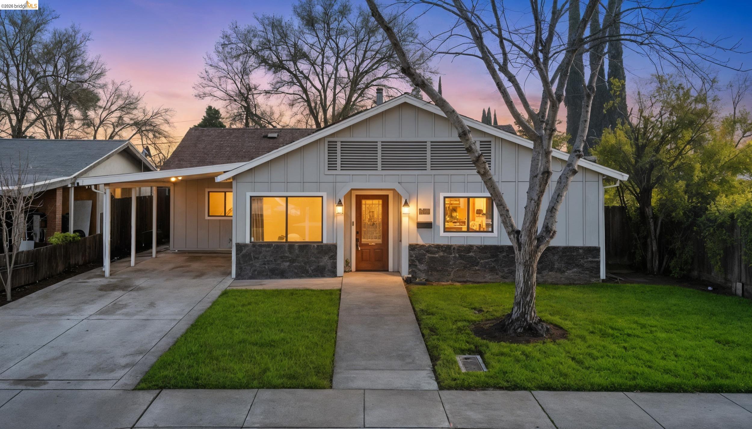1704 East Street Tracy, CA 95376 - Photo 2 of 29 View of front facade featuring board and batten siding, an attached carport, and concrete driveway