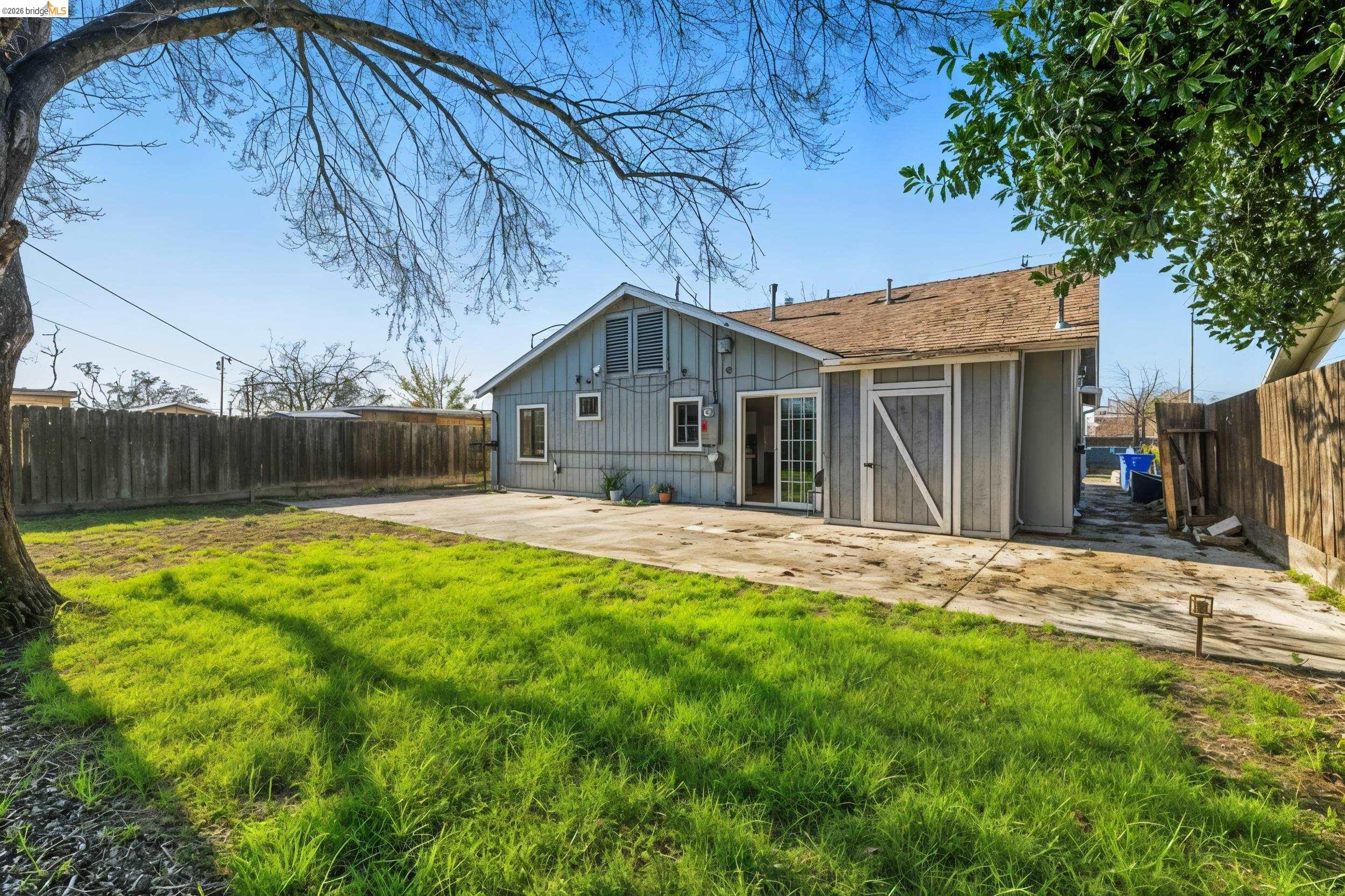 1704 East Street Tracy, CA 95376 - Photo 21 of 29 Rear view of property featuring a fenced backyard, board and batten siding, and a patio
