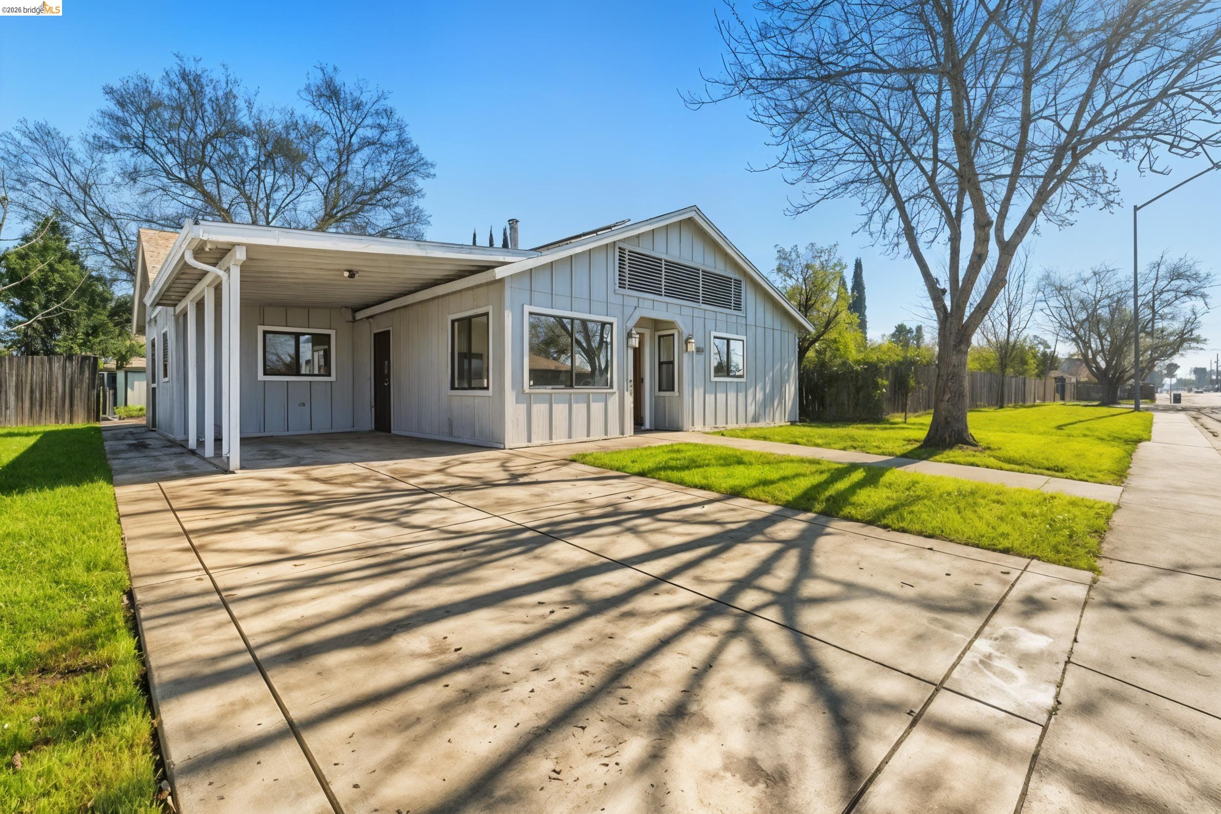 1704 East Street Tracy, CA 95376 - Photo 3 of 29 Rear view of property featuring a carport, concrete driveway, and board and batten siding