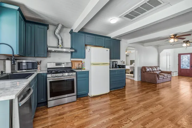 a kitchen with sink a refrigerator and a stove