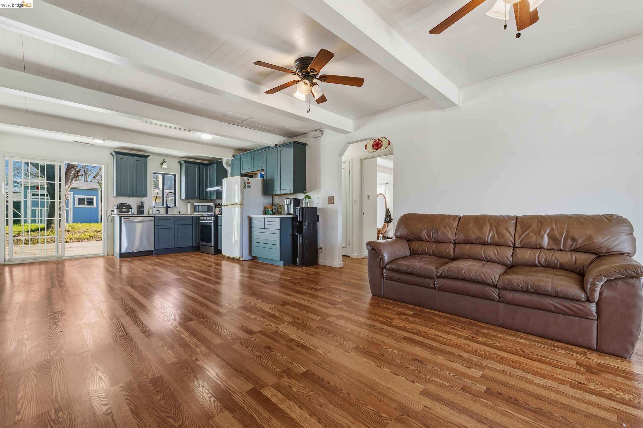 1704 East Street Tracy, CA 95376 - Photo 7 of 29 Living area with ceiling fan, beamed ceiling, dark wood-style floors, and arched walkways