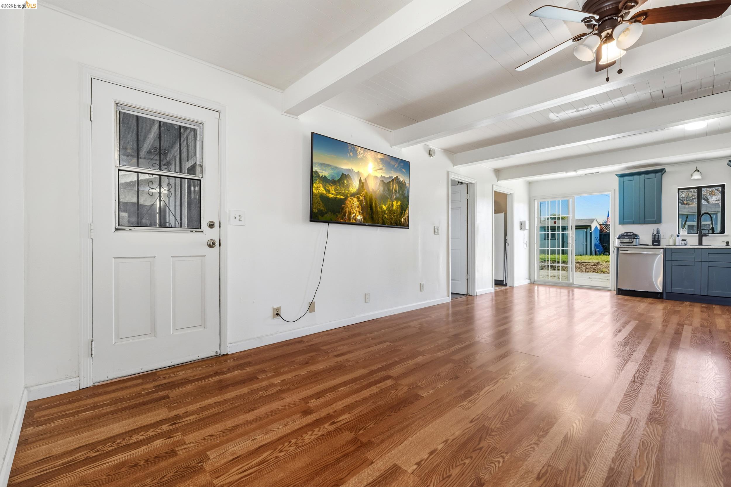 1704 East Street Tracy, CA 95376 - Photo 8 of 29 Unfurnished living room with light wood finished floors, beam ceiling, and ceiling fan