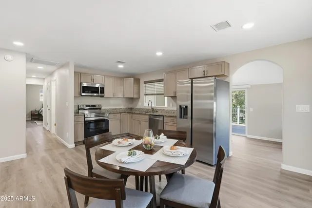 a kitchen with refrigerator cabinets dining table and chairs