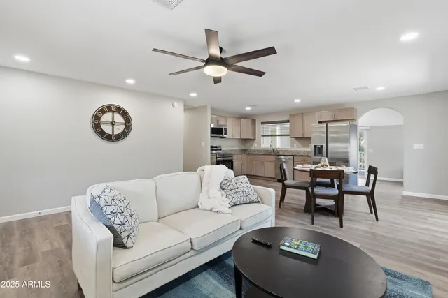a living room with furniture kitchen view and a chandelier