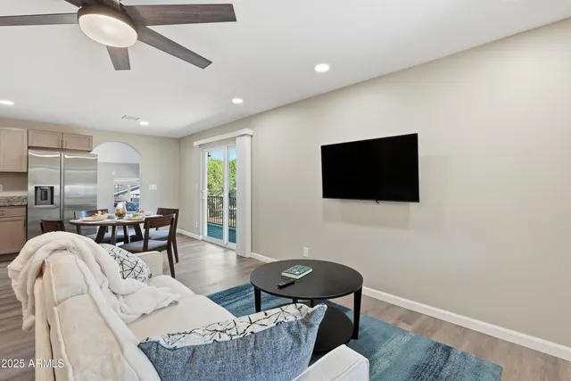 a living room with furniture a flat screen tv and kitchen view