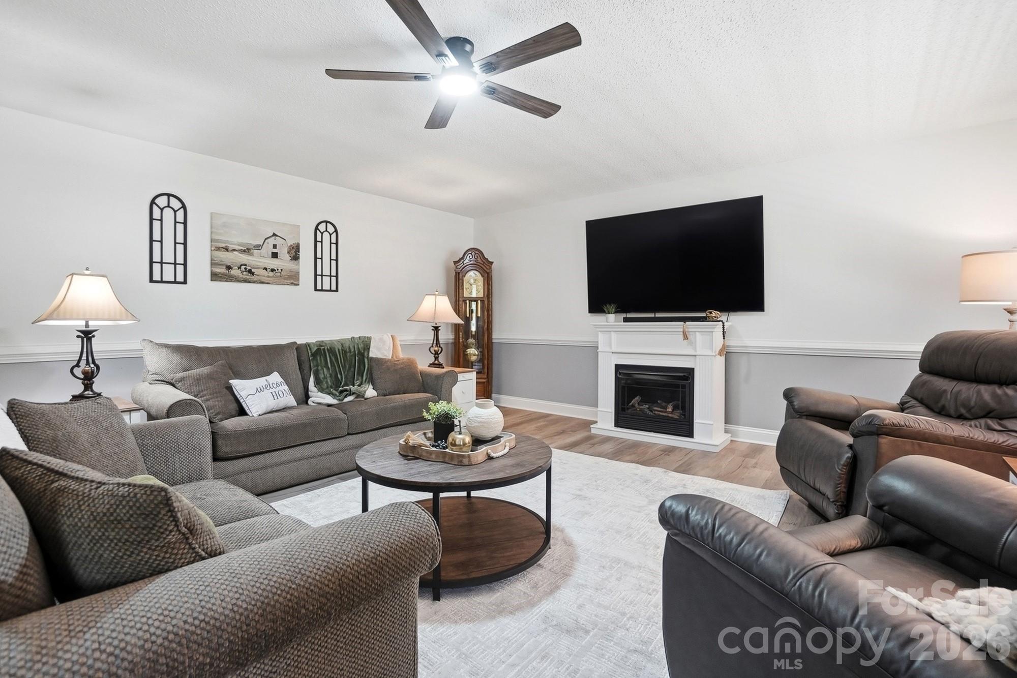 4017 Mullis Newsome Road Monroe, NC 28110 - Photo 13 of 38 a living room with furniture a fireplace and a flat screen tv