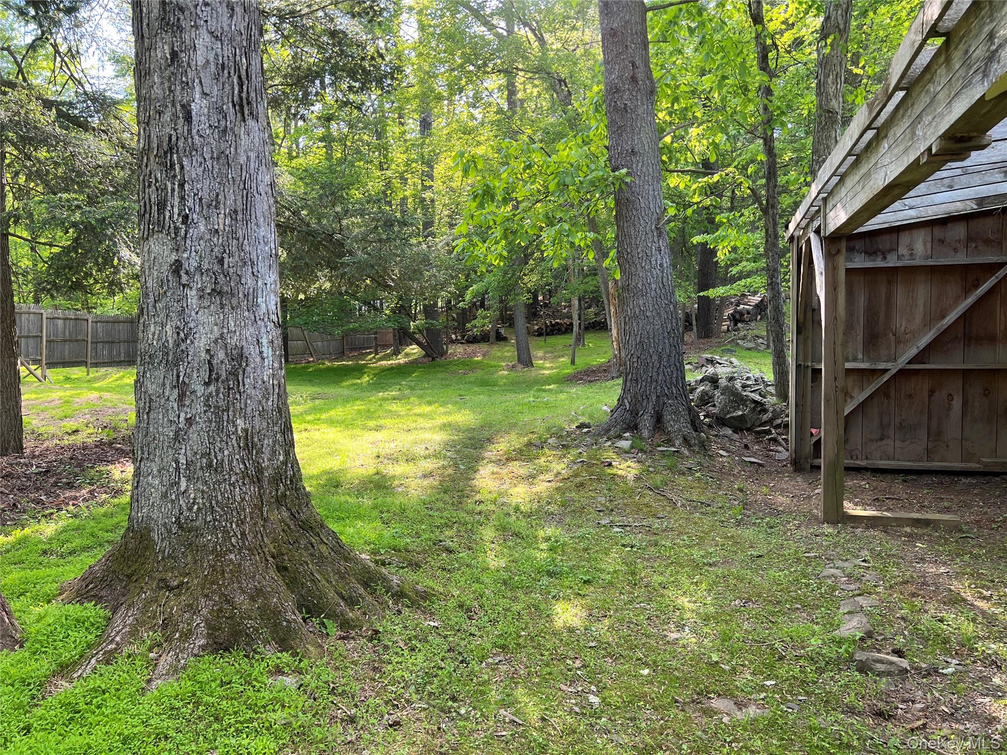 404 John Joy Road Saugerties, NY 12477 - Photo 23 of 50 a view of a backyard with large trees and wooden fence