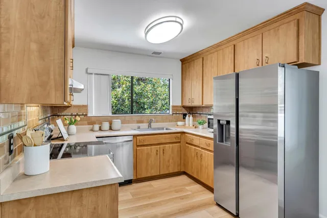 a kitchen with a sink a refrigerator and cabinets