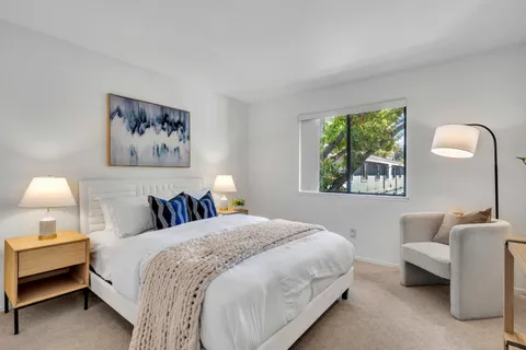 a bedroom with a bed wooden floor and a chandelier