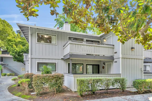 a front view of a house with a yard and potted plants