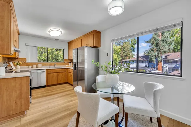 a kitchen with a table chairs refrigerator and cabinets