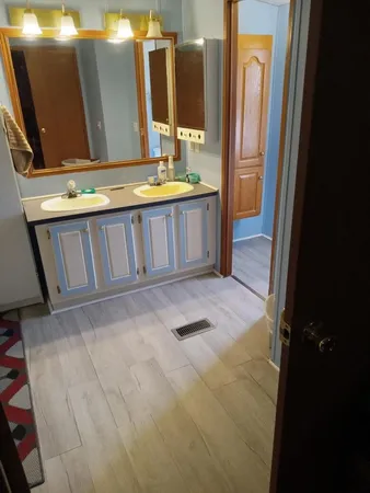 a bathroom with double vanity and a mirror