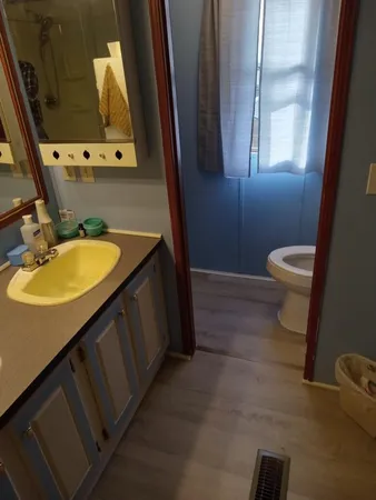 a bathroom with a granite countertop sink toilet and mirror