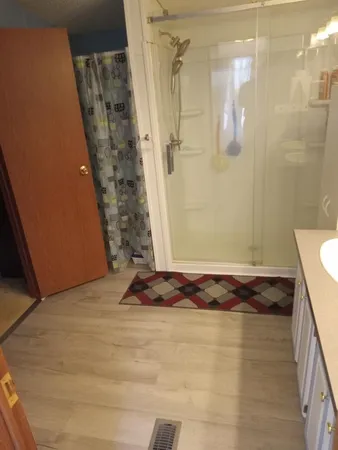 a bathroom with a granite countertop shower a sink and a toilet