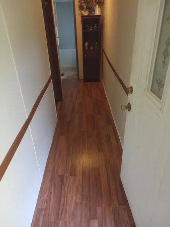 a view of a hallway with wooden floor and staircase