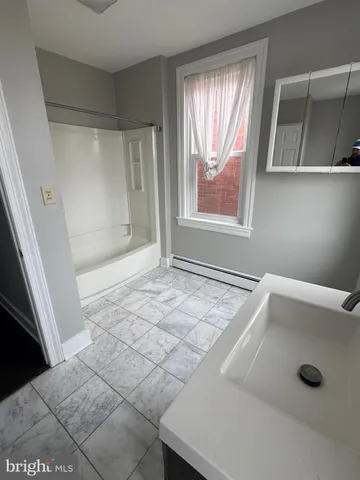 a bathroom with a tub a window and a shower