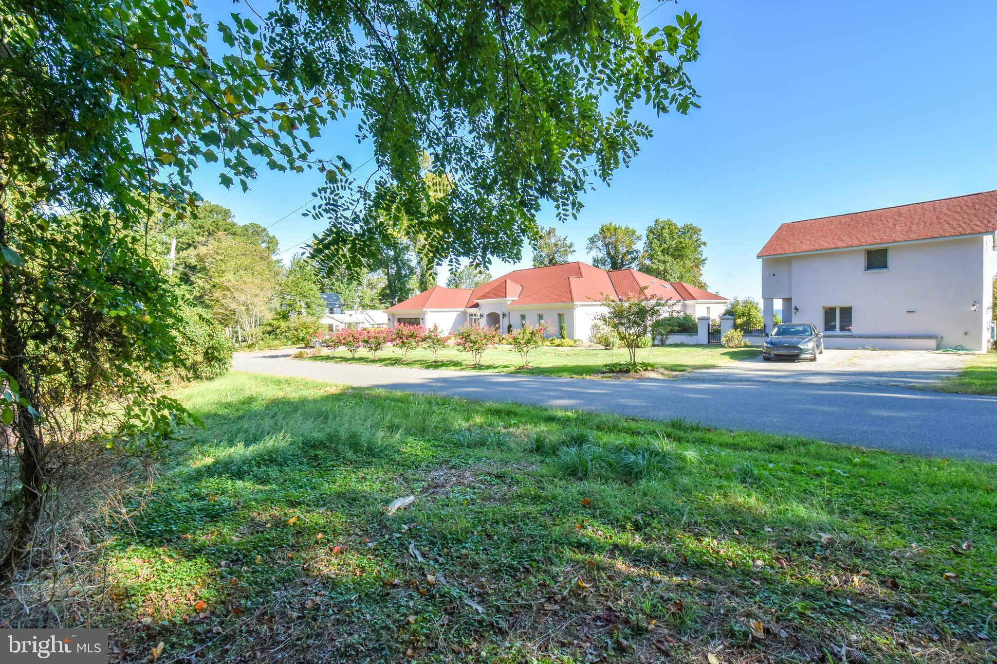 6041 Hill Road St. Leonard, MD 20685 - Photo 5 of 17 a view of green field with house in the background