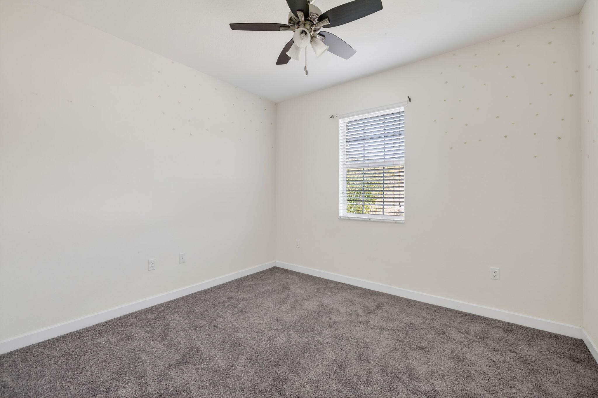 9504 Southwest Otter Lane Stuart, FL 34997 - Photo 26 of 36 an empty room with a ceiling fan and windows
