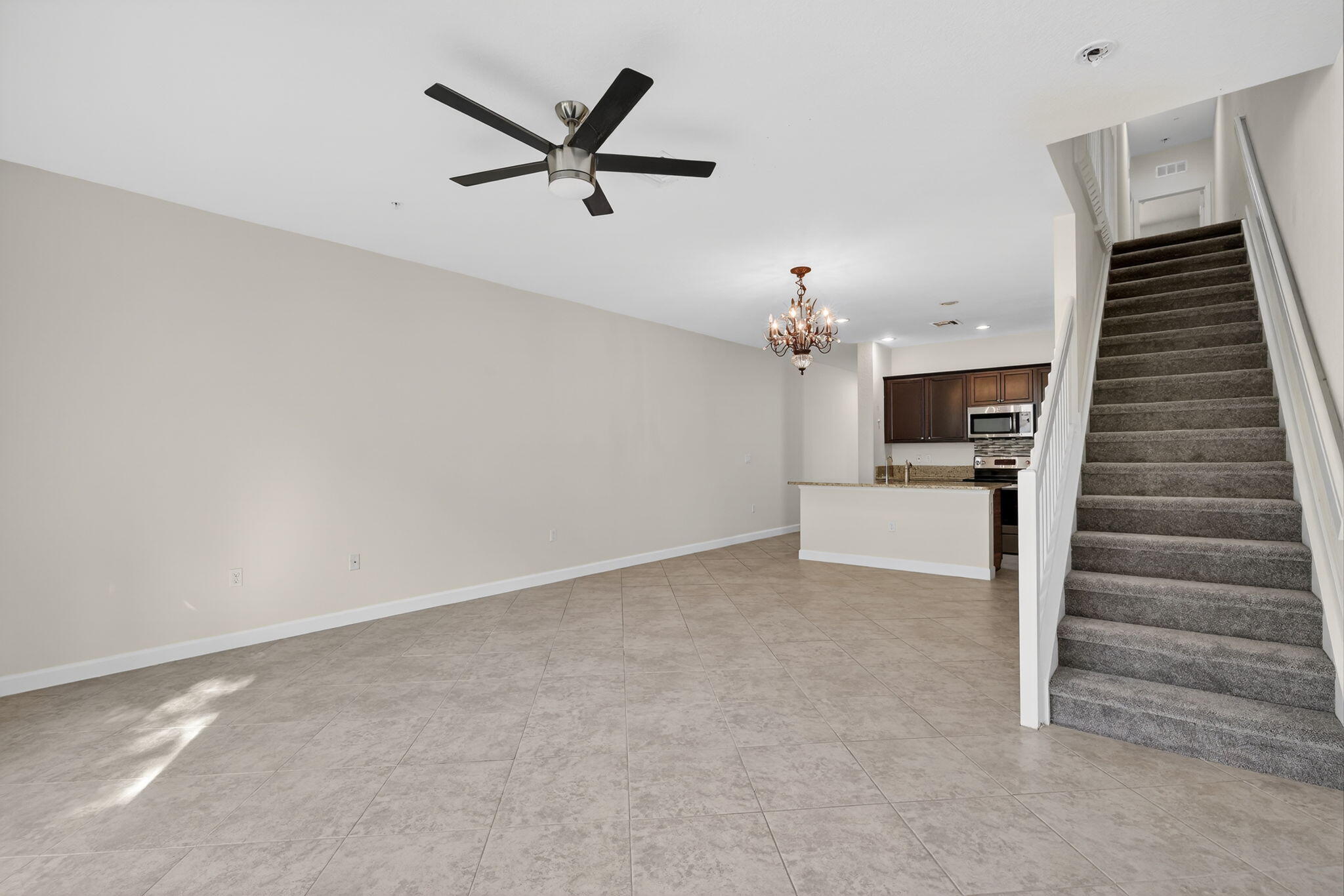 9504 Southwest Otter Lane Stuart, FL 34997 - Photo 4 of 36 a view of a livingroom with a ceiling fan stairs and a chandelier fan
