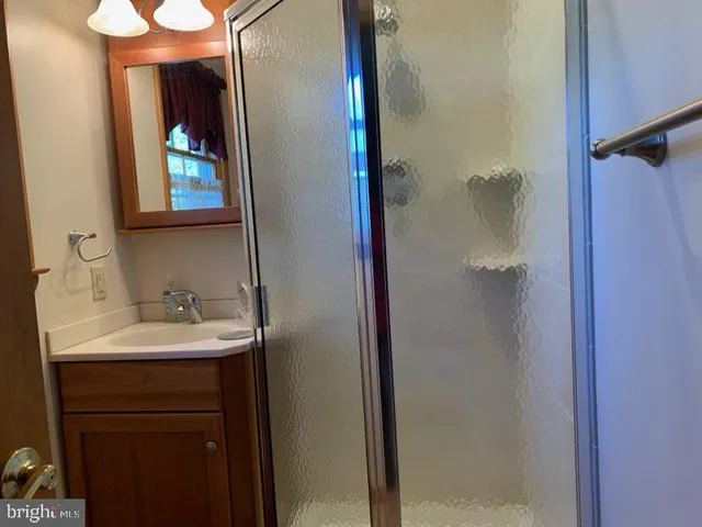 a kitchen with stainless steel appliances granite countertop a refrigerator a sink dishwasher and wooden cabinets with wooden floor