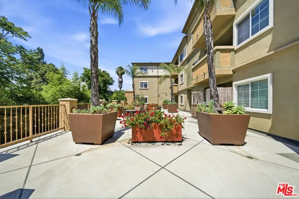 a view of a patio with couches and potted plants