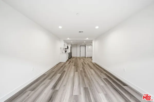a view of empty room with wooden floor