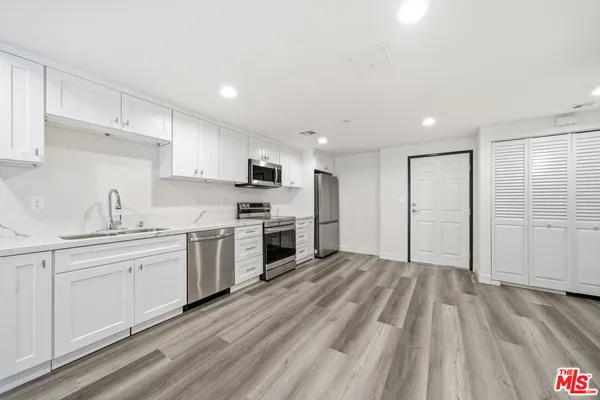 a kitchen with granite countertop a sink stainless steel appliances and cabinets