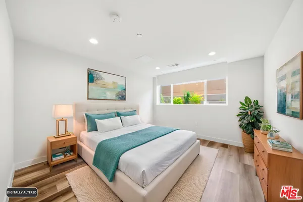a bedroom with a bed and a potted plant