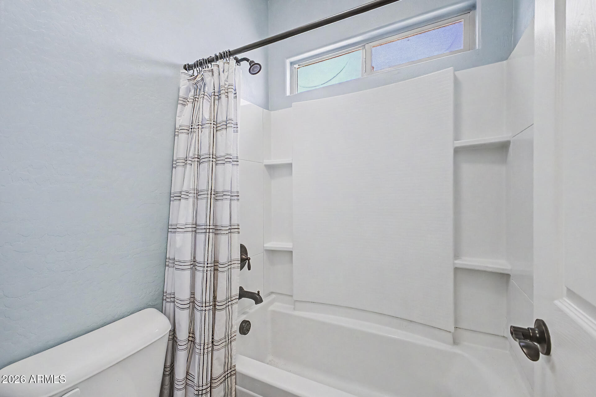 16719 West Rowel Road Surprise, AZ 85387 - Photo 19 of 28 a bathroom with a shower curtain and a bathtub