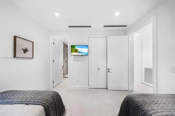 a bedroom with a bed and a large window