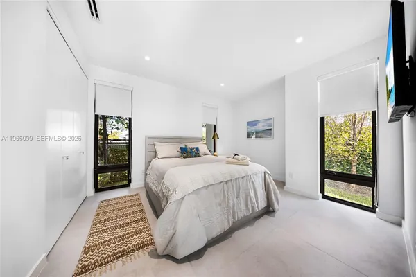 a spacious bedroom with a bed a couch and a potted plant