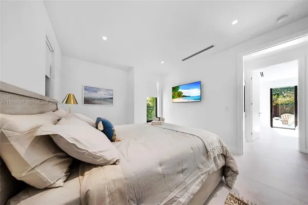 a bedroom with a large bed and a flat screen tv