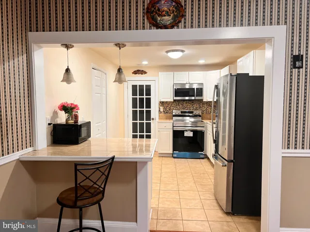a kitchen with stainless steel appliances kitchen island granite countertop a refrigerator and a stove top oven