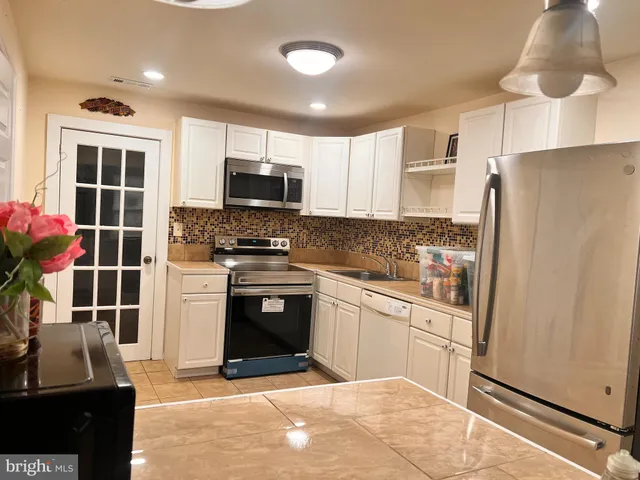 a kitchen with stainless steel appliances a stove refrigerator sink and microwave