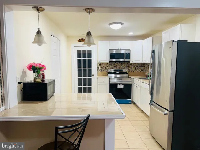 a kitchen with stainless steel appliances a stove a refrigerator a sink and a refrigerator