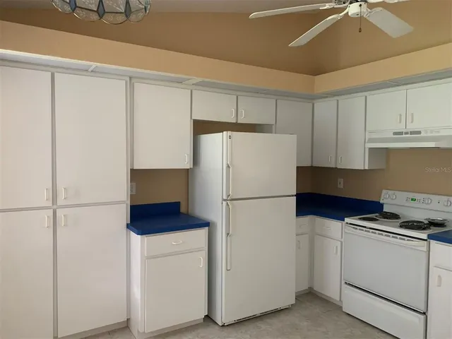 a white refrigerator freezer and a stove sitting inside of a kitchen