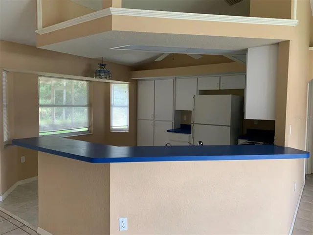a kitchen with cabinets and wooden floor