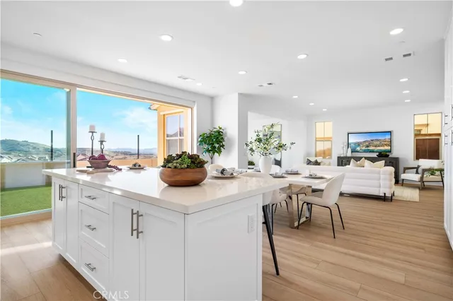 a kitchen with white cabinets and window