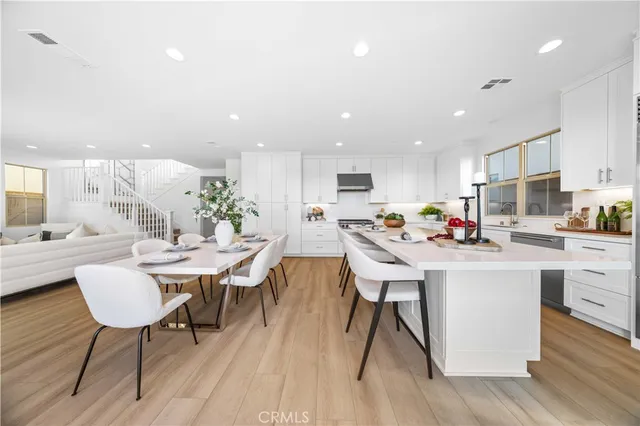a kitchen with a dining table chairs and view of living room